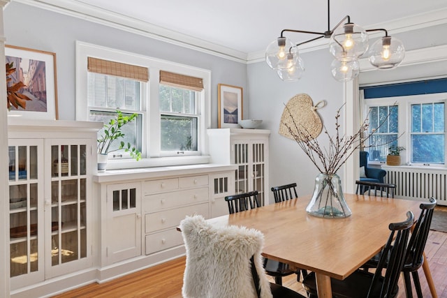 1310 Fairmount Ave, Saint Paul, MN 55105 - dining room featuring light wood-type flooring, radiator heating unit, and ornamental molding