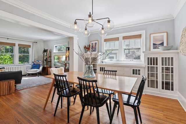 1310 Fairmount Ave, Saint Paul, MN 55105 - dining room with radiator, crown molding, light wood-style flooring, and a chandelier