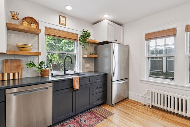 1310 Fairmount Ave, Saint Paul, MN 55105 - kitchen with open shelves, stainless steel appliances, radiator heating unit, a sink, and dark countertops