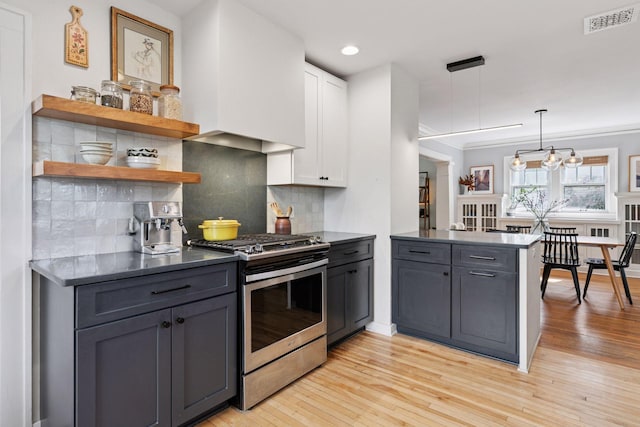 1310 Fairmount Ave, Saint Paul, MN 55105 - kitchen with gas stove, a peninsula, dark countertops, white cabinetry, and decorative backsplash