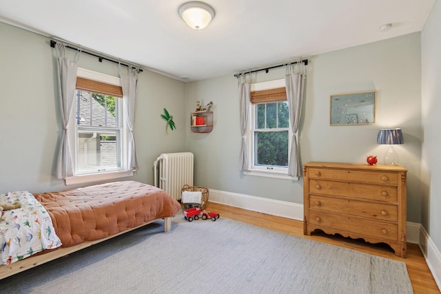 1310 Fairmount Ave, Saint Paul, MN 55105 - bedroom with radiator heating unit, wood finished floors, and baseboards
