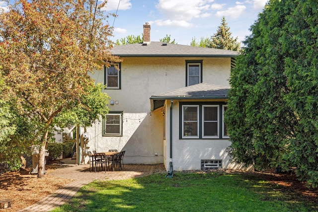 1310 Fairmount Ave, Saint Paul, MN 55105 - rear view of house with stucco siding, a chimney, a lawn, and a patio