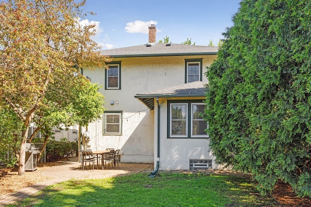 1310 Fairmount Ave, Saint Paul, MN 55105 - rear view of property featuring stucco siding, a chimney, a yard, and a patio
