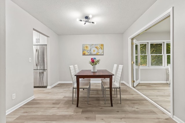 228 16th Ave SW, New Brighton, MN 55112 - dining space featuring a textured ceiling, light wood-style flooring, and baseboards