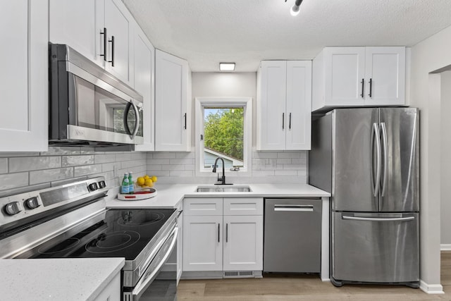 228 16th Ave SW, New Brighton, MN 55112 - kitchen with appliances with stainless steel finishes, a sink, white cabinetry, and a textured ceiling