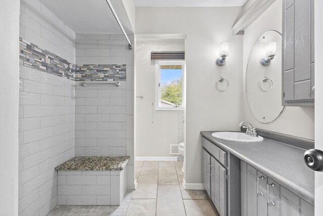 228 16th Ave SW, New Brighton, MN 55112 - full bathroom with a tile shower, toilet, vanity, tile patterned flooring, and baseboards
