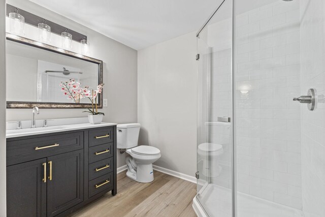 228 16th Ave SW, New Brighton, MN 55112 - bathroom featuring toilet, wood finished floors, a shower stall, vanity, and baseboards