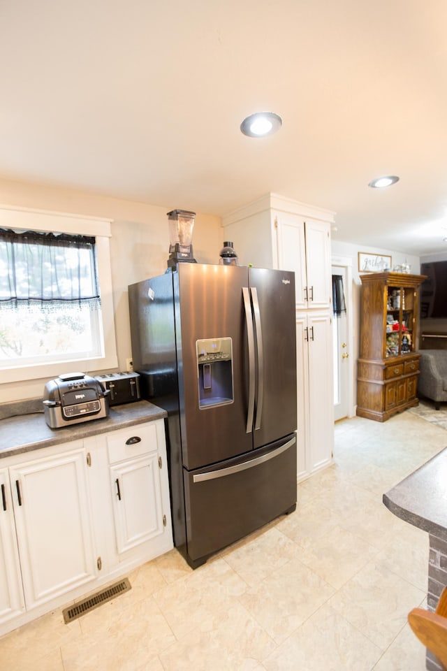 2758 220th St, Madison, MN 56256 - kitchen with stainless steel fridge, white cabinets, recessed lighting, and light tile patterned flooring