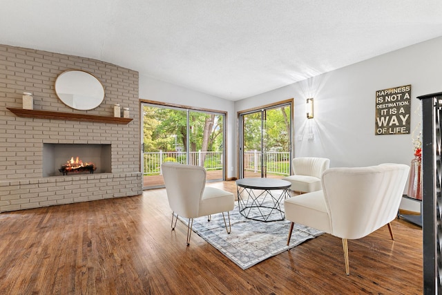 708 Brigadoon Cir, Shoreview, MN 55126 - living room featuring wood finished floors, vaulted ceiling, a brick fireplace, and a textured ceiling
