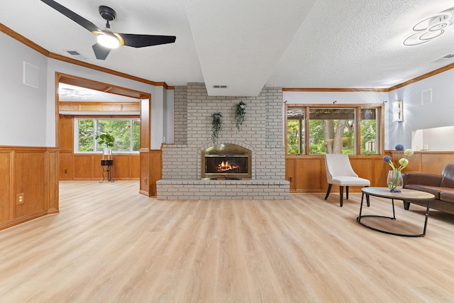 708 Brigadoon Cir, Shoreview, MN 55126 - living room featuring a wainscoted wall, wood finished floors, ornamental molding, a fireplace, and a ceiling fan