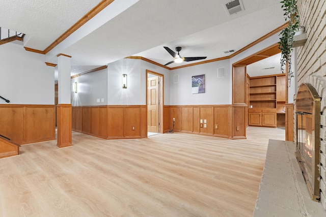 708 Brigadoon Cir, Shoreview, MN 55126 - unfurnished living room with crown molding, wainscoting, wood finished floors, a ceiling fan, and a textured ceiling