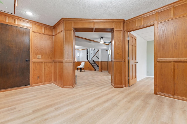 708 Brigadoon Cir, Shoreview, MN 55126 - spare room with light wood-style floors, a textured ceiling, stairs, and wooden walls