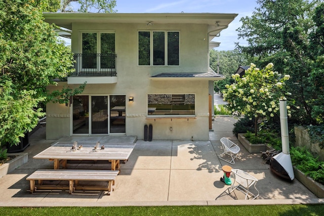 1824 Oliver Ave S, Minneapolis, MN 55405 - rear view of property with stucco siding, a patio area, and a balcony