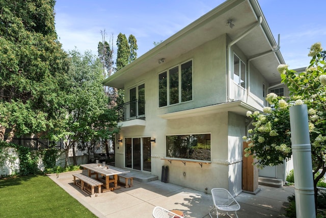 1824 Oliver Ave S, Minneapolis, MN 55405 - rear view of property with a balcony, stucco siding, a patio area, and outdoor dining area