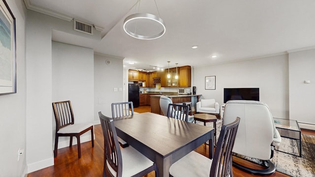 1425 28th St Unit 519, Minneapolis, MN 55408 - dining space featuring recessed lighting, crown molding, dark wood finished floors, and baseboards