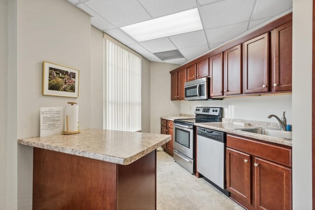 1425 28th St Unit 519, Minneapolis, MN 55408 - kitchen with appliances with stainless steel finishes, a sink, a drop ceiling, light countertops, and a peninsula