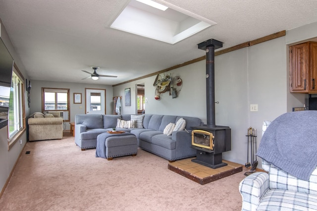 692 Round Lake Ln, Georgetown Twp, WI 54853 - living area featuring a wood stove, light colored carpet, ceiling fan, and a textured ceiling