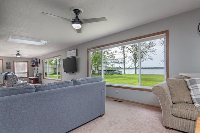 692 Round Lake Ln, Georgetown Twp, WI 54853 - living area with a ceiling fan, a textured ceiling, a skylight, baseboards, and light colored carpet