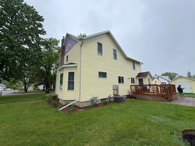 809 14th St S, Benson, MN 56215 - rear view of house with a chimney, a deck, a lawn, and central AC