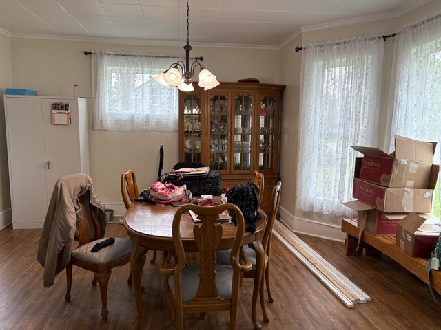 809 14th St S, Benson, MN 56215 - dining space with wood finished floors, a chandelier, crown molding, and baseboards