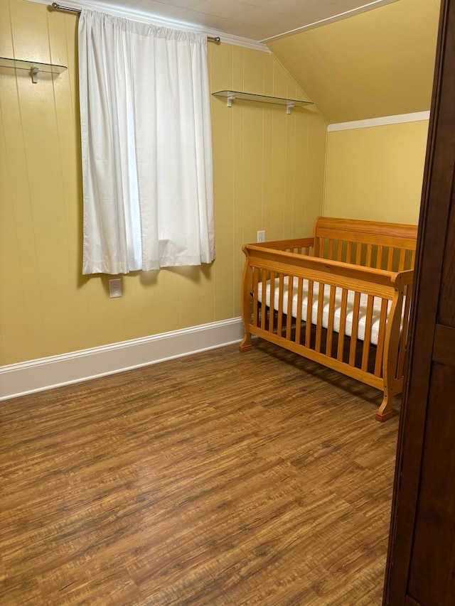 809 14th St S, Benson, MN 56215 - bedroom featuring baseboards, wood finished floors, lofted ceiling, and a crib