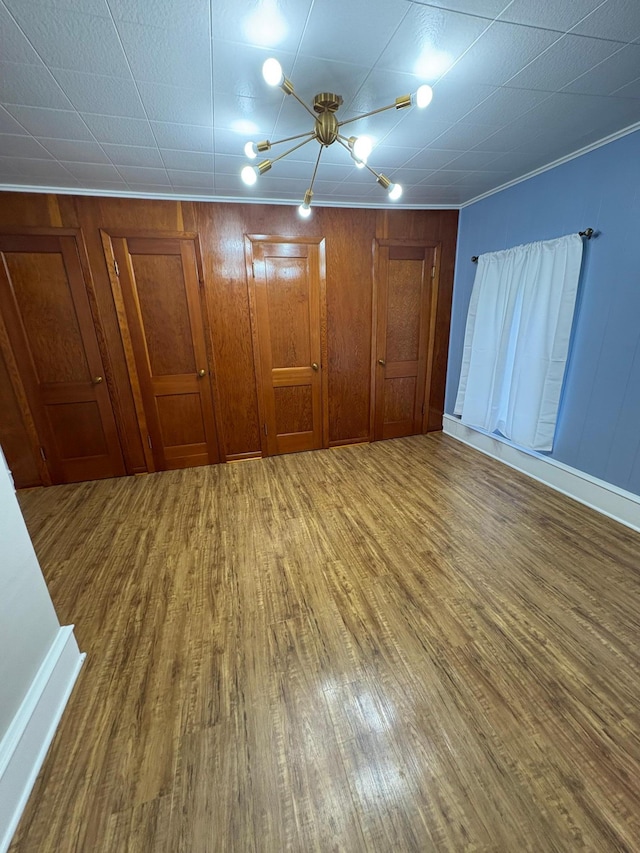 809 14th St S, Benson, MN 56215 - unfurnished bedroom featuring wood finished floors, a chandelier, baseboards, and ornamental molding