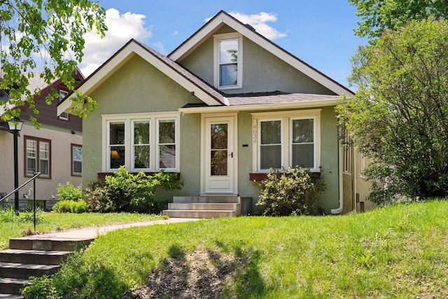 4034 Nokomis Ave, Minneapolis, MN 55406 - view of front of house with stucco siding, entry steps, a front lawn, and roof with shingles