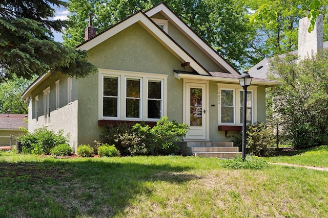 4034 Nokomis Ave, Minneapolis, MN 55406 - bungalow with a chimney, stucco siding, a front yard, and entry steps