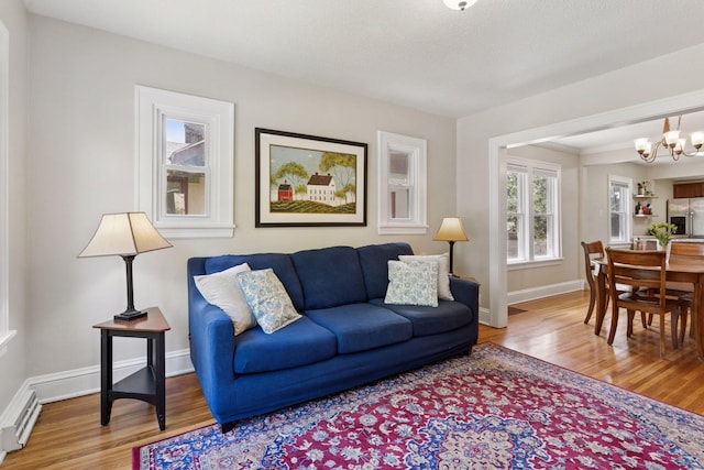 4034 Nokomis Ave, Minneapolis, MN 55406 - living room featuring wood finished floors, a baseboard radiator, a chandelier, and baseboards