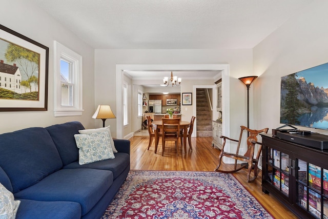 4034 Nokomis Ave, Minneapolis, MN 55406 - living area featuring a chandelier, wood finished floors, baseboards, and stairway