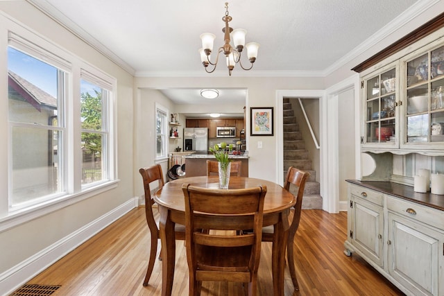 4034 Nokomis Ave, Minneapolis, MN 55406 - dining room featuring stairway, a chandelier, light wood-type flooring, baseboards, and ornamental molding