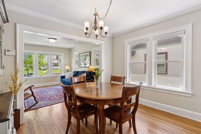 4034 Nokomis Ave, Minneapolis, MN 55406 - dining area featuring light wood finished floors, a chandelier, baseboards, and crown molding