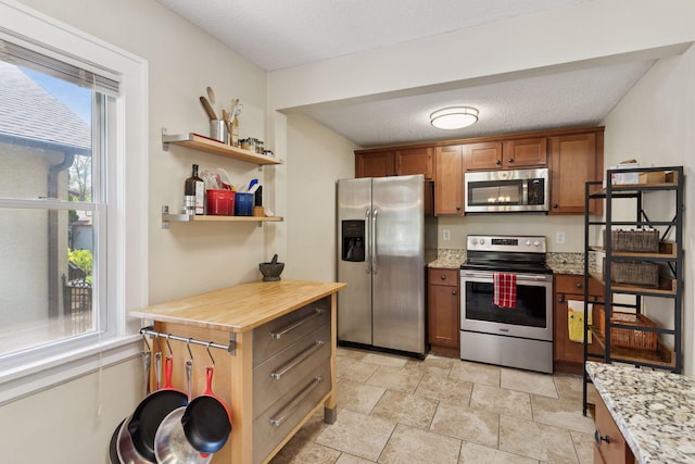 4034 Nokomis Ave, Minneapolis, MN 55406 - kitchen with stainless steel appliances, healthy amount of natural light, brown cabinetry, open shelves, and a textured ceiling