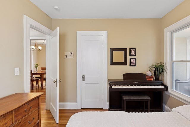 4034 Nokomis Ave, Minneapolis, MN 55406 - bedroom featuring a chandelier, wood finished floors, and baseboards