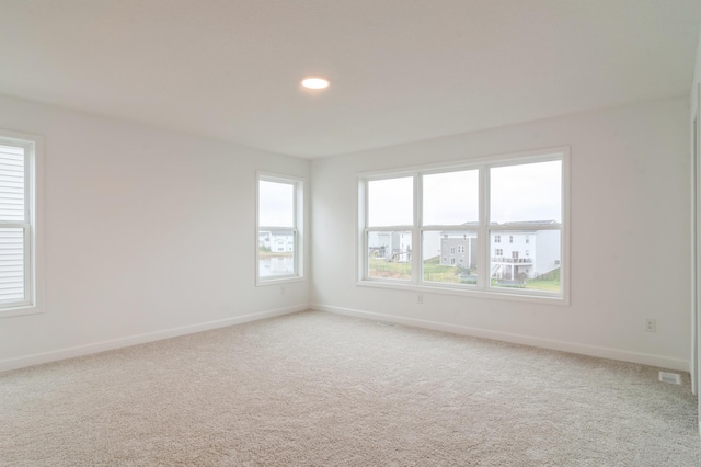 carpeted spare room featuring baseboards and recessed lighting