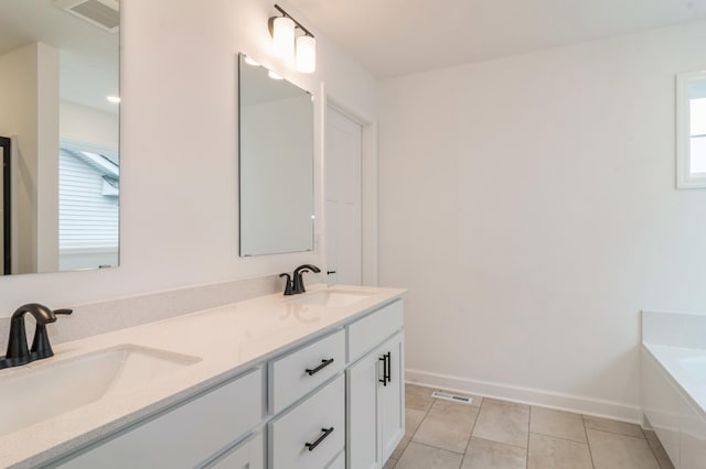 bathroom with plenty of natural light, baseboards, tile patterned flooring, and double vanity