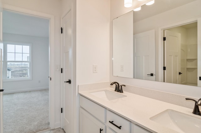 bathroom with double vanity and baseboards