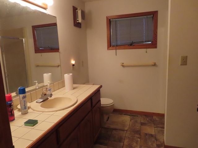 114 2nd St S, Truman, MN 56088 - full bathroom featuring a shower stall, vanity, baseboards, toilet, and stone finish flooring