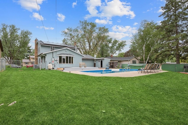 2197 Beam Ave, Maplewood, MN 55109 - rear view of property featuring roof mounted solar panels, a chimney, cooling unit, and a patio