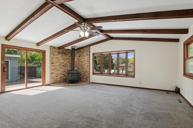 2197 Beam Ave, Maplewood, MN 55109 - unfurnished living room featuring a wood stove, plenty of natural light, carpet flooring, and a ceiling fan