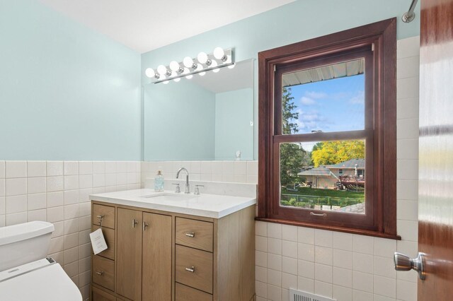 2197 Beam Ave, Maplewood, MN 55109 - half bath featuring tile walls, toilet, and vanity