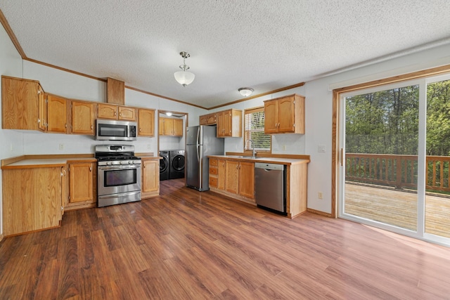 58885 County Road 136, Menahga, MN 56464 - kitchen featuring appliances with stainless steel finishes, washing machine and dryer, ornamental molding, dark wood-style flooring, and a textured ceiling