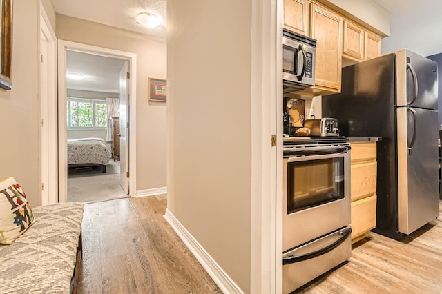 2727 43rd St Unit 102, Minneapolis, MN 55410 - kitchen with stainless steel appliances, light brown cabinetry, light wood finished floors, and baseboards