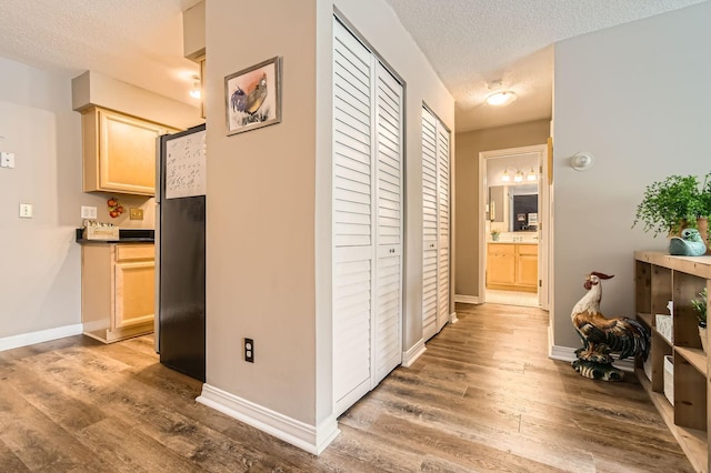 2727 43rd St Unit 102, Minneapolis, MN 55410 - corridor featuring a textured ceiling, wood finished floors, and baseboards
