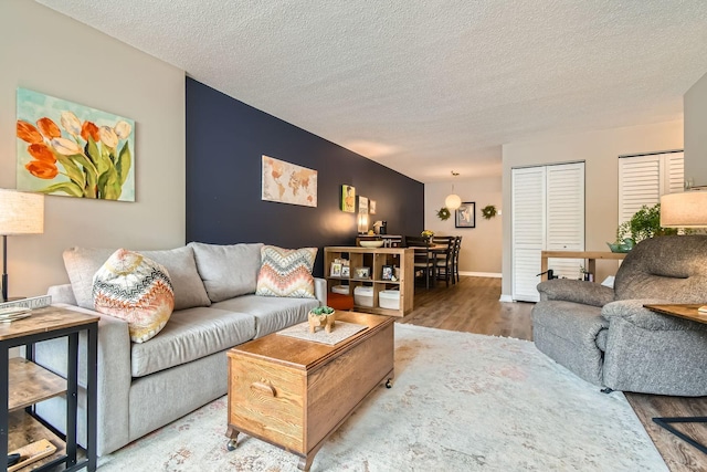 2727 43rd St Unit 102, Minneapolis, MN 55410 - living room with wood finished floors, a textured ceiling, and baseboards