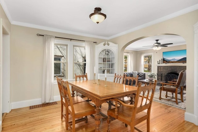 1750 Sims Ave, Saint Paul, MN 55106 - dining room with ceiling fan, healthy amount of natural light, arched walkways, light wood-type flooring, and ornamental molding