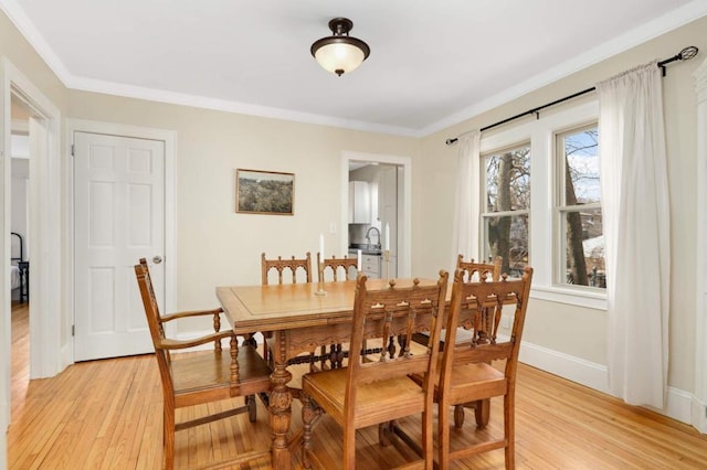 1750 Sims Ave, Saint Paul, MN 55106 - dining area with light wood-style floors, crown molding, and baseboards
