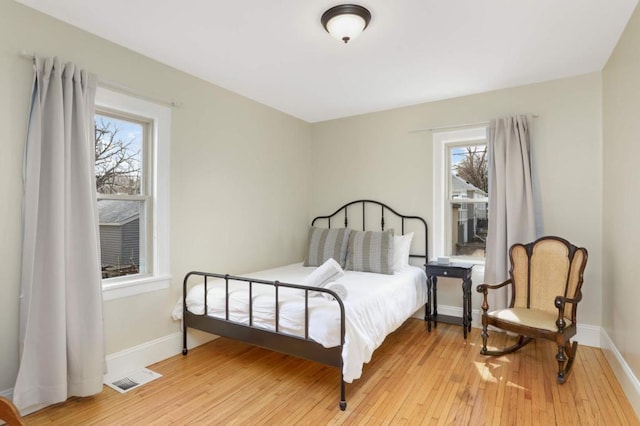 1750 Sims Ave, Saint Paul, MN 55106 - bedroom with multiple windows, hardwood / wood-style floors, and baseboards