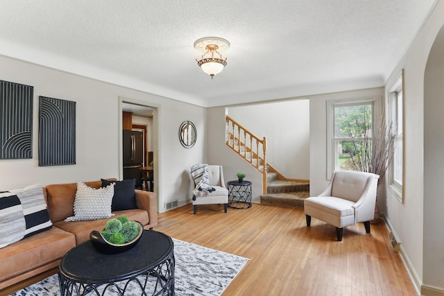 218 Owens St N, Stillwater, MN 55082 - living area featuring stairway, light wood finished floors, a textured ceiling, and baseboards