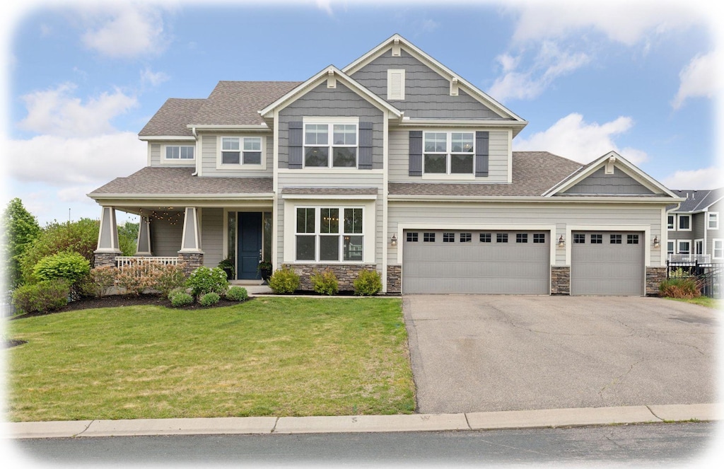 11285 Deerwood Ln N, Dayton, MN 55369 - craftsman house with a porch, stone siding, driveway, a front yard, and a shingled roof